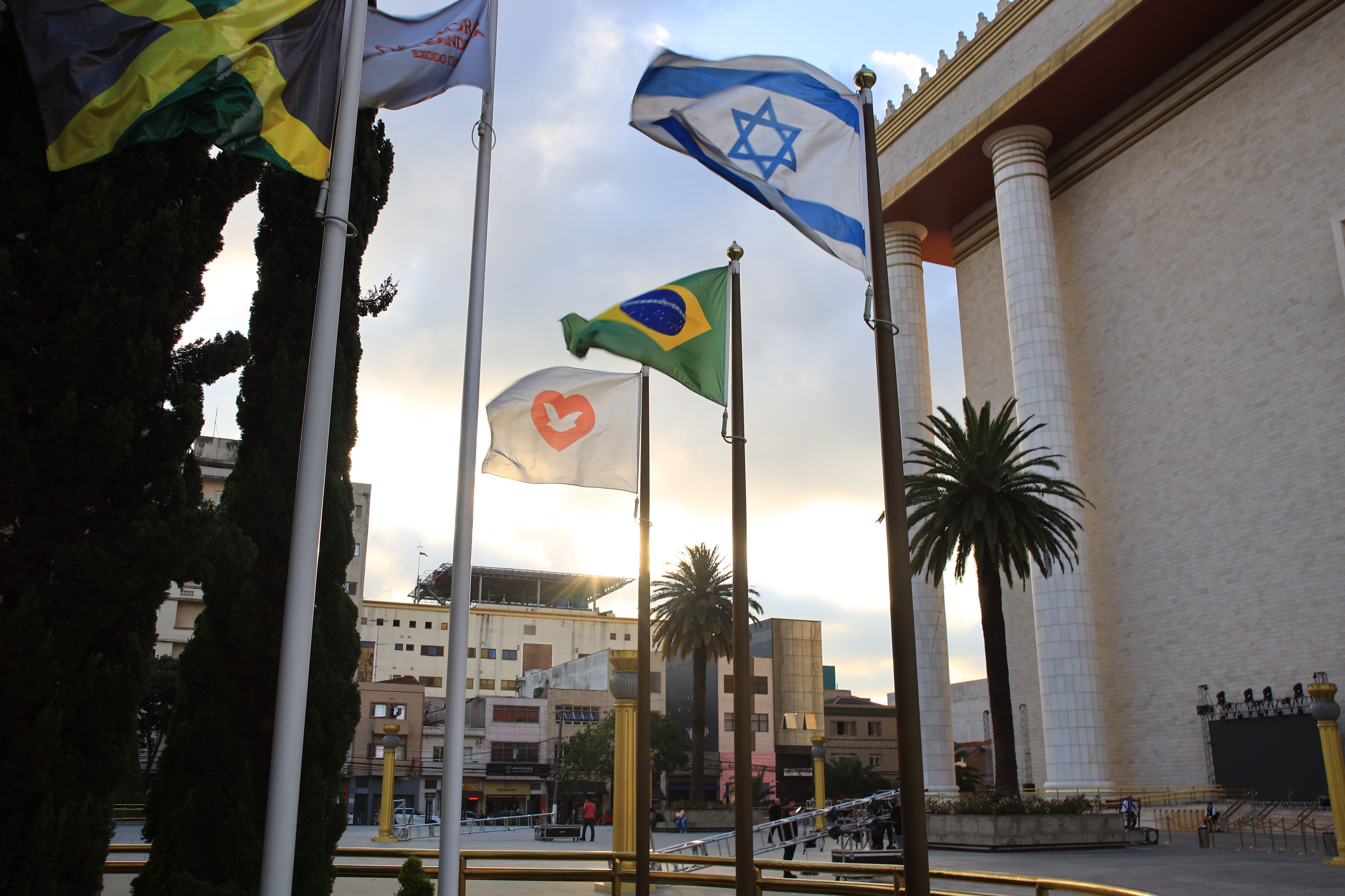 Flags waving in front of the iconic Temple of Solomon in São Paulo, Brazil, under a cloudy sky. — Foto: Th2city Santana / Pexels