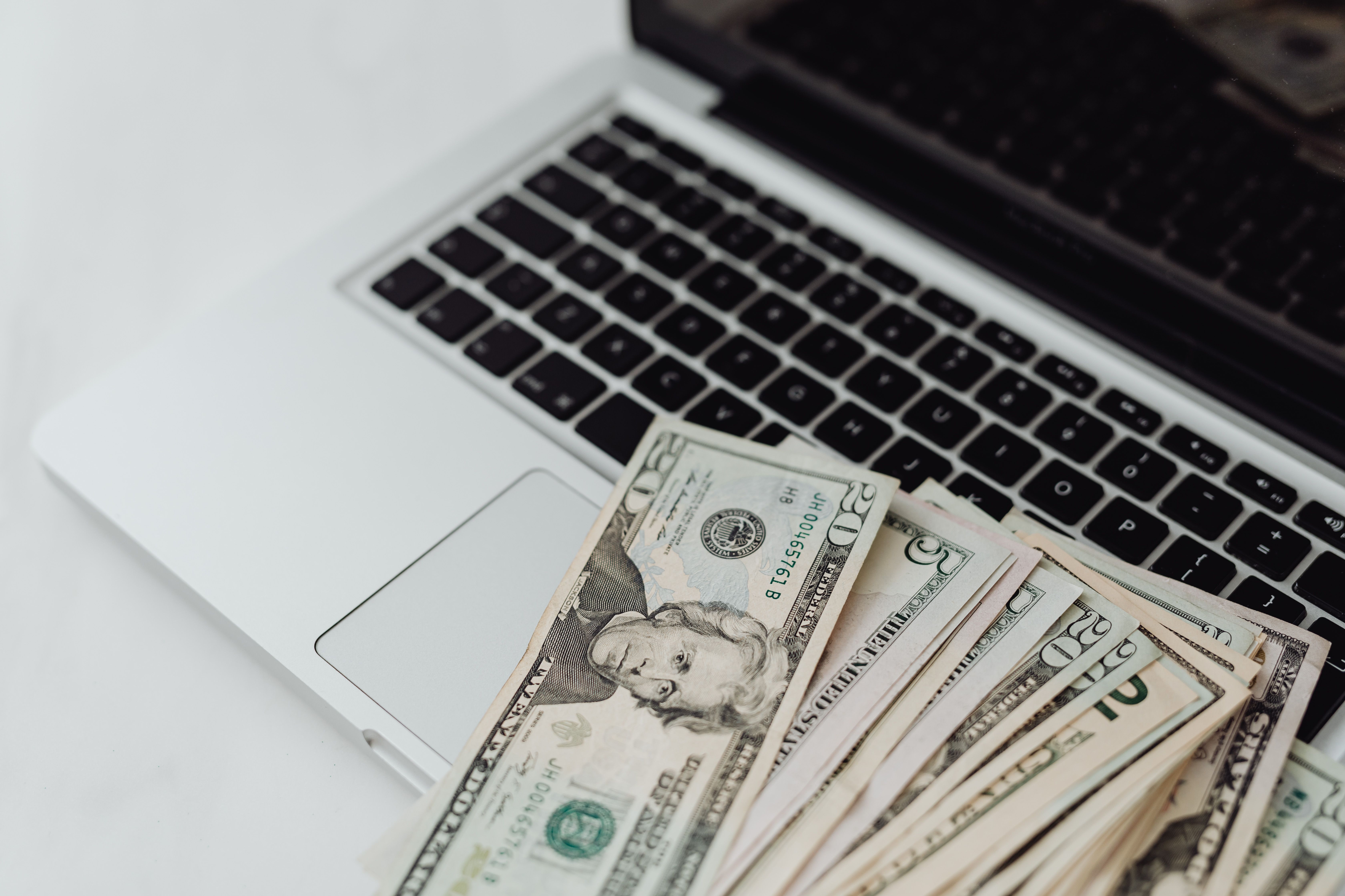 Close-up of US dollar banknotes on a laptop keyboard symbolizing online finance and technology. — Foto: https://kaboompics.com/ / Pexels