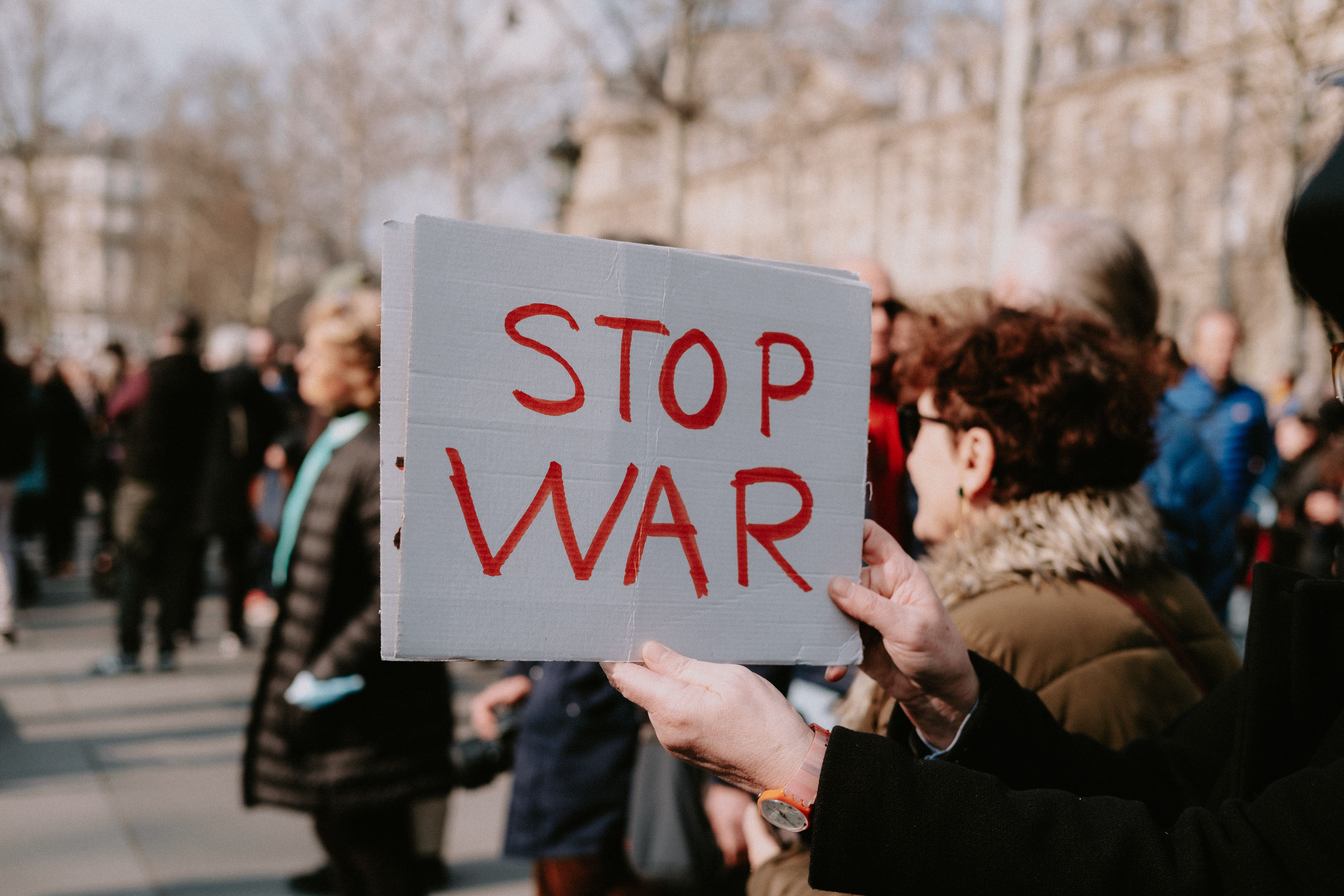 Crowd of people in a peaceful protest holding a 'Stop War' sign outdoors. — Foto: Mathias Reding / Pexels