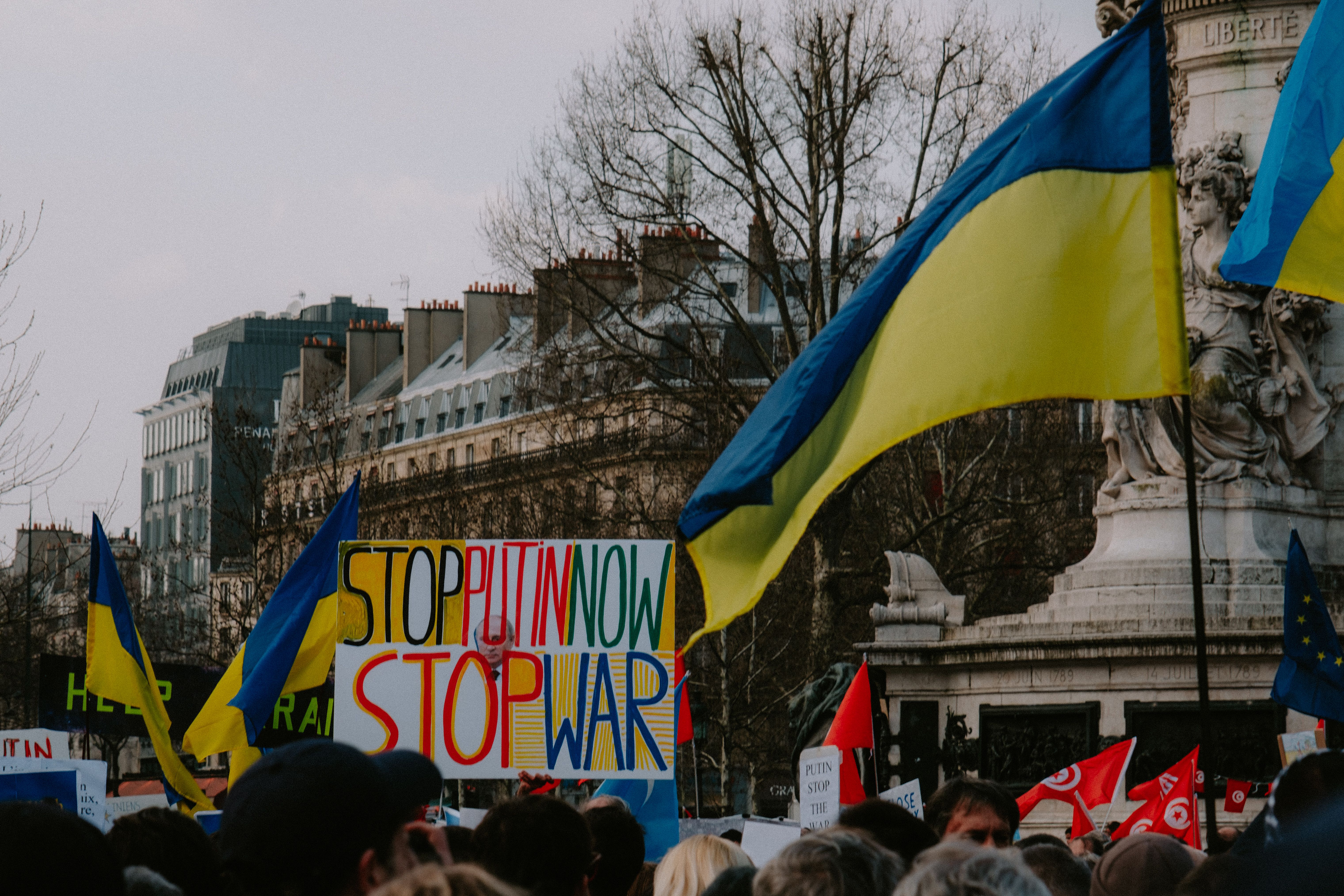 A dynamic crowd in Paris rallies with Ukrainian flags and anti-war signs, advocating peace. — Foto: Mathias Reding / Pexels